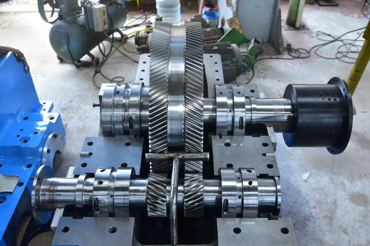 Double-helical bull gear meshed with its pinion, set on journal bearings in the gearbox casing